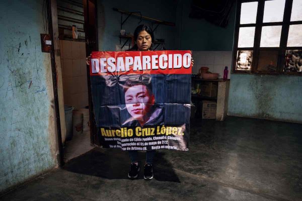 Araceli Cruz López, mujer indígena tzotzil, con pancarta de su hermano Aurelio, migrante desaparecido.