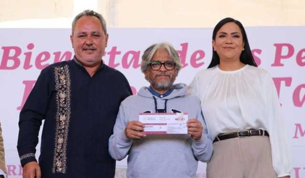La imagen original muestra a un beneficiario sosteniendo con las dos manos su sobre y le acompañan la secretaria de Bienestar, Ariadna Montiel Reyes, y el secretario de Inclusión y Bienestar Social del gobierno de la Ciudad de México, Rigoberto Salgado.