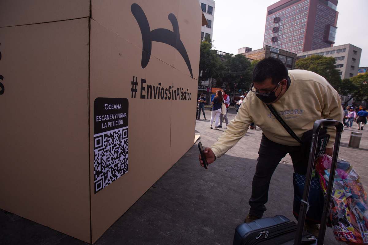 Una persona registra el QR de la campaña de Oceana para eliminar el uso de plásticos innecesarios.