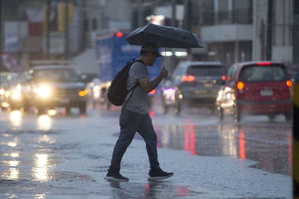Persona bajo la lluvia causada por un frente frío