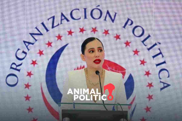 Sandra Cuevas con el logo de su partido a espaldas. Letras azules, estrellas rojas