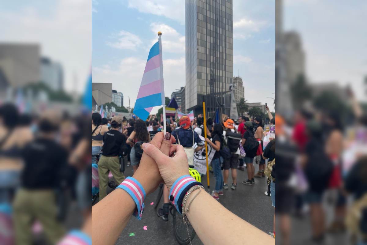 Las manos de dos madres sostienen una bandera trans, en la marcha por la visibilidad trans el 31 de marzo de 2024 en la Ciudad de México.
