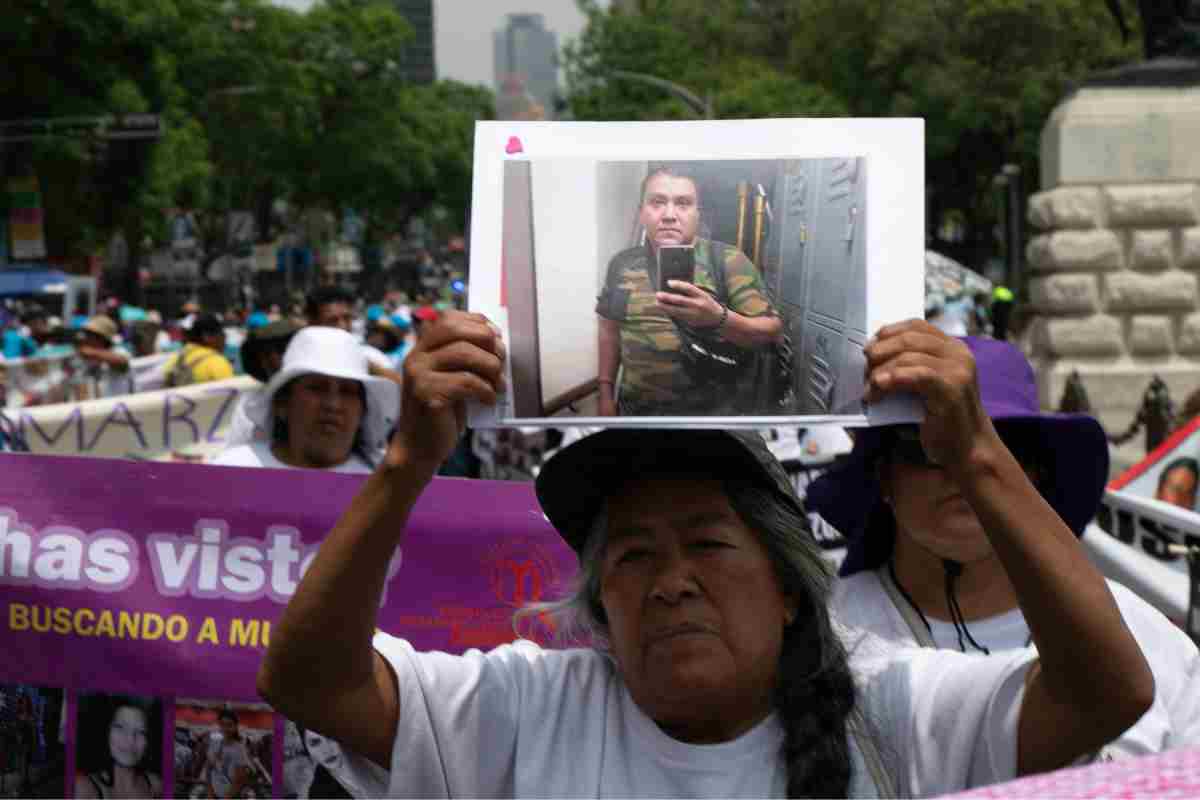 Madre buscadora y foto de su hijo desaparecido.