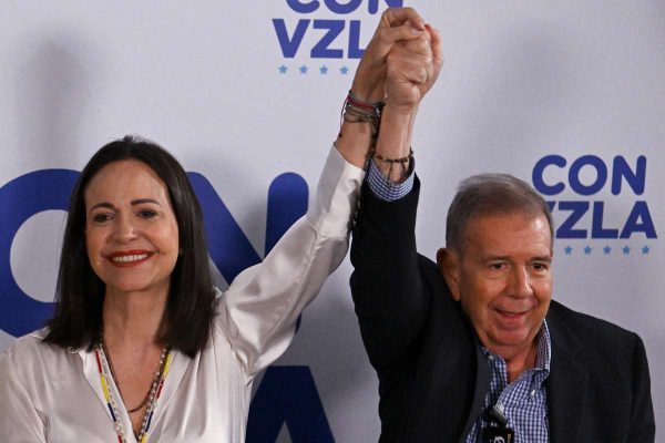María Corina Machado levanta la mano del candidato presidencial opositor Edmundo González Urrutia