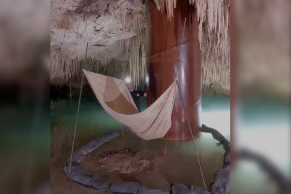 Uso de una lona para detener la filtración de hidrocarburos por la infraestructura del Tren Maya en la caverna de un cenote. 