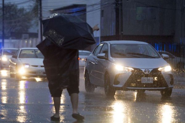 personas caminando debajo de las lluvias en nuevo león