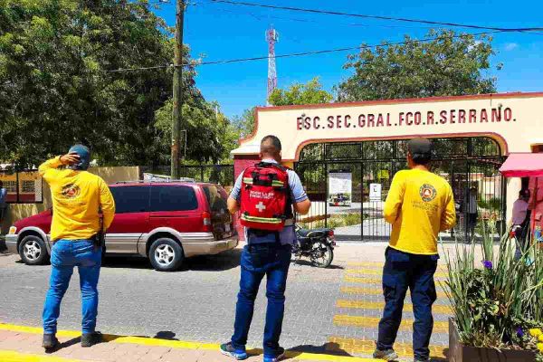 Personal de protección civil y paramédicos al exterior de una secundaria en Choix, comunidad donde tuvieron que rescatar a un maestro