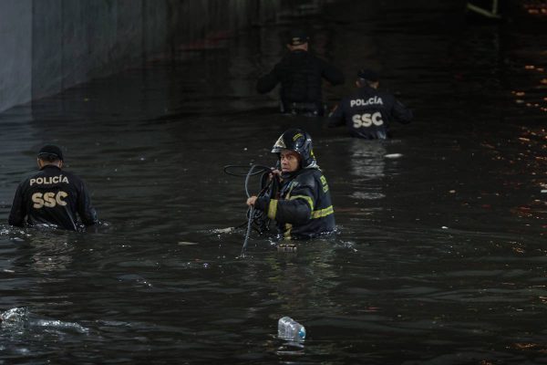 Bomberos en un bajo puente inundado por las fuertes lluvias en cdmx
