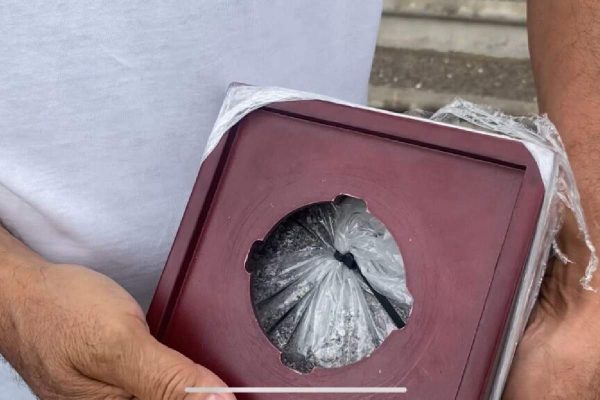 Familiar del primer cuerpo identificado entre los 383 cadáveres del crematorio muestra la urna que fue abierta como parte del proceso de identificación.