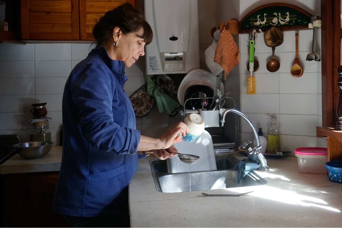 Adriana Contarini lava los platos con agua de la canilla en su casa en Nueve de Julio. A pesar de vivir en el centro —una zona que se supone recibe agua potable—, los análisis que ella misma encargó detectaron niveles de arsénico por encima de los límites seguros. Ahora evita beberla o usarla para cocinar. Foto: Lucila Pellettieri, GPJ Argentina