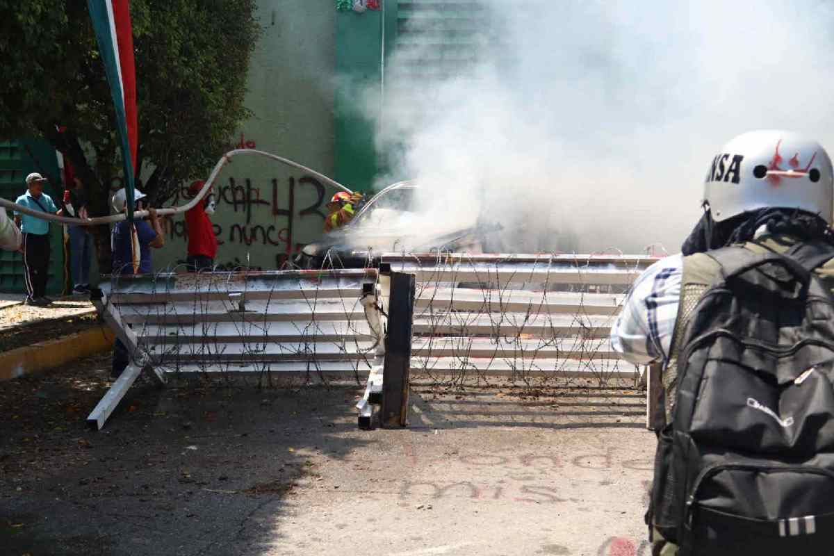 Normalistas protestan frente al 27 Batallón de Infantería en Iguala; incendian camioneta y lanzan petardos