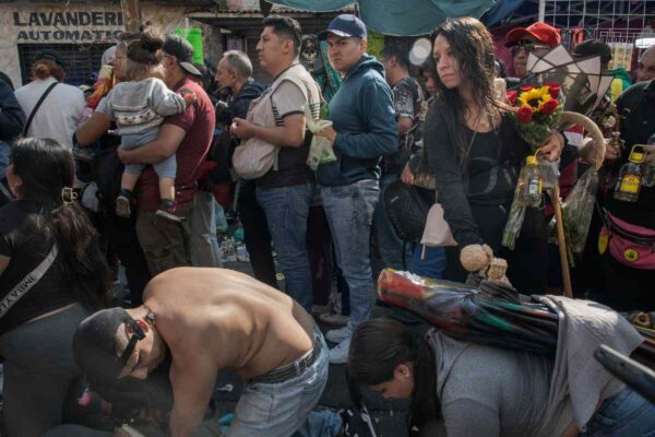 Hombres y mujeres figuras de la Santas Muerte y arrodilladas