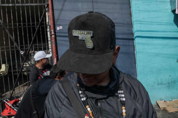 hombre gorra pistola festejo santa muerte