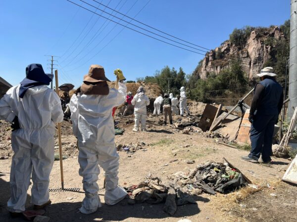 Con trajes tyvek, buscadores esperan su turno para relevar al grupo de personas que busca en un punto de interés para la jornada. Foto: Jennifer Flores
